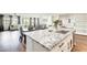 View from kitchen island, shows a granite countertop, sink, modern faucet, and open layout to living and dining areas at 24441 N 142Nd Dr, Surprise, AZ 85387