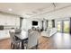 Open-concept living space with a cozy sitting area and a kitchen with white cabinets and stainless steel appliances at 24441 N 142Nd Dr, Surprise, AZ 85387