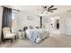 Well-lit main bedroom with a window view, a ceiling fan, and a view to the main bathroom and closet at 24441 N 142Nd Dr, Surprise, AZ 85387