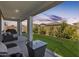 Inviting covered patio with comfortable seating and a view of the manicured lawn at 24441 N 142Nd Dr, Surprise, AZ 85387