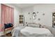 Cozy spa room with pink accent drapes, an oval mirror, storage cabinets and a comfortable medical bed at 24441 N 142Nd Dr, Surprise, AZ 85387