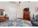 Cozy bedroom with blue patchwork quilt, dresser and TV, and mirrored vanity at 24617 N 49Th Ave, Glendale, AZ 85310