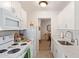 Galley kitchen with white cabinets, marble countertops, and modern appliances at 24617 N 49Th Ave, Glendale, AZ 85310