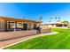 Home's backyard featuring a well-maintained lawn, patio area, and desert landscaping at 25261 S Berry Brook Dr, Sun Lakes, AZ 85248