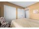 Bedroom with white closet doors and a patterned chair at 25261 S Berry Brook Dr, Sun Lakes, AZ 85248