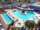 Aerial view of a luxurious community pool and jacuzzi surrounded by lounge chairs and palm trees at 25261 S Berry Brook Dr, Sun Lakes, AZ 85248