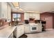 Bright kitchen with white cabinetry, white appliances, and tiled flooring at 25261 S Berry Brook Dr, Sun Lakes, AZ 85248