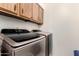 Modern laundry room featuring a Samsung washer and dryer set with wood cabinets above at 25261 S Berry Brook Dr, Sun Lakes, AZ 85248