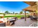 Relaxing patio area with comfortable seating and a view of the well-manicured lawn and green golf course at 25261 S Berry Brook Dr, Sun Lakes, AZ 85248