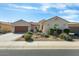 Well-maintained home featuring desert landscaping with lush green shrubs at 26249 W Abraham Ln, Buckeye, AZ 85396