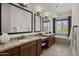 Well-lit bathroom features dual sinks, granite countertops, and a separate soaking tub with scenic views at 27000 N Alma School Pkwy # 1024, Scottsdale, AZ 85262
