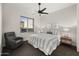 This primary bedroom boasts neutral decor, an overhead fan, a comfy reading chair, and large windows at 27000 N Alma School Pkwy # 1024, Scottsdale, AZ 85262