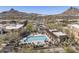 A community pool with a hot tub, lounge chairs, desert landscaping, and mountains in the distance at 27000 N Alma School Pkwy # 1024, Scottsdale, AZ 85262