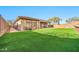 Expansive backyard with manicured lawn, covered patio, and privacy fencing at 3138 W Ravina Ln, Anthem, AZ 85086
