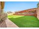 Backyard featuring artificial turf, tiered planting beds, and privacy wall, perfect for outdoor enjoyment at 3138 W Ravina Ln, Anthem, AZ 85086