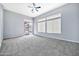 Bright bedroom features a ceiling fan, carpet, and a sliding door to the backyard at 3138 W Ravina Ln, Anthem, AZ 85086