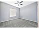 Cozy carpeted bedroom has a ceiling fan and a large window with blinds at 3138 W Ravina Ln, Anthem, AZ 85086