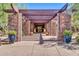 Clubhouse entrance with covered portico, stone pillars, lush landscaping, and large potted plants at 3138 W Ravina Ln, Anthem, AZ 85086