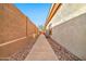 Long side yard pathway with neutral tones and xeriscape, providing access and visual appeal at 3138 W Ravina Ln, Anthem, AZ 85086