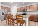 Open concept kitchen with granite countertops, wood cabinets, stainless appliances, and breakfast bar seating at 35751 N Bandolier Dr, San Tan Valley, AZ 85144