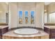 Relaxing bathroom showcasing a large soaking tub, with bright windows for natural light and a stone surround at 37170 N Granite Creek Ln, Carefree, AZ 85377