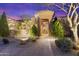 Home exterior featuring desert landscaping, stone walkway, and covered entryway with elegant iron gate at 37170 N Granite Creek Ln, Carefree, AZ 85377