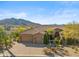 Stunning exterior view of a Southwestern-style home with a tile roof, three car garage, and desert landscaping at 37170 N Granite Creek Ln, Carefree, AZ 85377