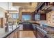 Stylish kitchen with dark wood cabinetry, granite counters, and picturesque window views at 37170 N Granite Creek Ln, Carefree, AZ 85377
