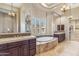 Elegant main bathroom with a soaking tub, dual vanities, and natural light at 37170 N Granite Creek Ln, Carefree, AZ 85377