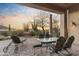 Inviting covered patio with outdoor furniture overlooks desert landscape and fountain views at 37170 N Granite Creek Ln, Carefree, AZ 85377