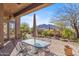 Inviting covered patio features an outdoor dining area with desert views and a charming water fountain at 37170 N Granite Creek Ln, Carefree, AZ 85377