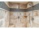 Detailed view of a tile shower featuring dual shower heads and a sleek design with travertine tile at 37170 N Granite Creek Ln, Carefree, AZ 85377