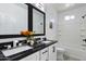 Bathroom with a double sink, black granite countertop and black framed mirror at 40715 W Georgia Ave, Tonopah, AZ 85354