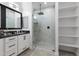 Bathroom showcasing a glass walk-in shower, dual sinks, and built-in shelves at 40715 W Georgia Ave, Tonopah, AZ 85354