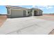 Wide concrete driveway leading to a beige single story home with a desert landscape at 40715 W Georgia Ave, Tonopah, AZ 85354