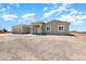 Exterior elevation of the beige single story home featuring a concrete driveway and desert landscape at 40715 W Georgia Ave, Tonopah, AZ 85354