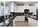 Bright kitchen features white cabinets, black marble countertops, and stainless steel appliances at 40715 W Georgia Ave, Tonopah, AZ 85354
