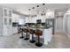 Open-concept kitchen features a large island with seating, white cabinets, and stainless appliances at 40715 W Georgia Ave, Tonopah, AZ 85354