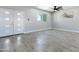 Bright open floor plan featuring gray floors, ceiling fan, and double front doors at 40715 W Georgia Ave, Tonopah, AZ 85354