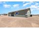 Rear view of the beige single story home featuring a large yard and desert landscape at 40715 W Georgia Ave, Tonopah, AZ 85354