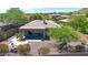 Private backyard oasis with a covered patio, lush greenery, and desert landscaping at 41229 N Belfair Way, Anthem, AZ 85086