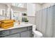Stylish bathroom with a gray vanity, gold hardware, and black-and-white shower curtain at 41229 N Belfair Way, Anthem, AZ 85086