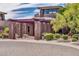 Elegant building entrance featuring stone pillars, lush landscaping, and a well-paved driveway at 41229 N Belfair Way, Anthem, AZ 85086
