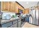 Well-lit kitchen featuring stainless steel appliances, granite countertops, and warm wood cabinetry at 41229 N Belfair Way, Anthem, AZ 85086