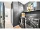 Laundry room with dark gray walls, gray front load washer and dryer, and shelving at 41229 N Belfair Way, Anthem, AZ 85086