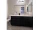A bathroom features a dark vanity with a white countertop and a large mirror at 4250 N 87Th Ln, Phoenix, AZ 85037