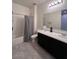 A bathroom features a shower, toilet and a dark vanity with a white countertop at 4250 N 87Th Ln, Phoenix, AZ 85037