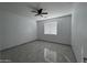 A light and airy bedroom with a ceiling fan and tile flooring at 4250 N 87Th Ln, Phoenix, AZ 85037