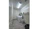 Functional laundry room featuring a washer, dryer, storage shelf and neutral tile flooring at 4250 N 87Th Ln, Phoenix, AZ 85037