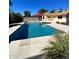 Outdoor pool area with tiled surround, sun umbrella, grass and patio space at 4665 E Aire Libre Ave, Phoenix, AZ 85032